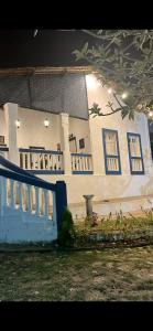 a house with a blue fence in front of it at Recanto Cravo & Canela in Meruoca