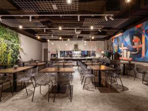 ein Restaurant mit Holztischen und Stühlen in einem Raum in der Unterkunft ibis Styles Ljubljana Centre in Ljubljana