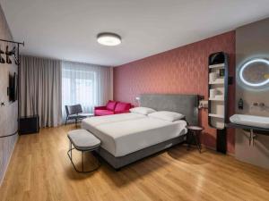 ein Schlafzimmer mit einem großen Bett und einer roten Wand in der Unterkunft ibis Styles Ljubljana Centre in Ljubljana + 57 Fotos