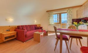 ein Wohnzimmer mit einem roten Sofa und einem Tisch in der Unterkunft Allesbauer - Familie Preis in Trebesing