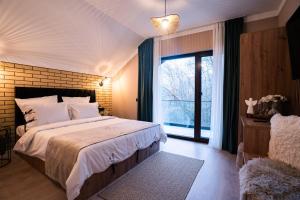 a bedroom with a large bed and a large window at Imperial Home Chalet in Sibiu