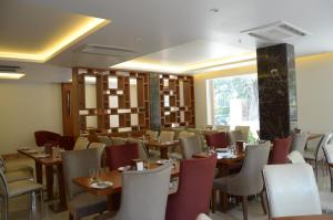 a dining room with tables and chairs and a window at Connaught Royale in New Delhi
