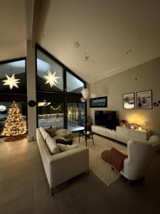 un soggiorno con un albero di Natale e un divano di Aurora Arctic Riverside Villa a Rovaniemi