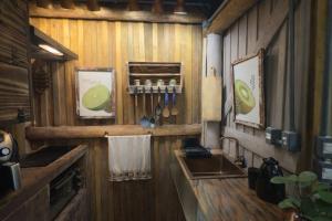 - une cuisine avec des murs en bois, un évier et un comptoir dans l'établissement Casa da Árvore - Pousada Jussara, à Joinville