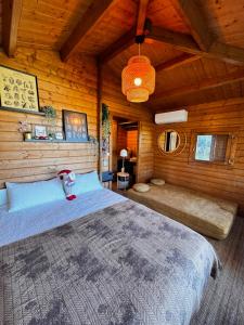una camera con un grande letto in una cabina di legno di The Bungalow - Heated Big Pool - New With Airconditioner a Almoster Altre 51 foto