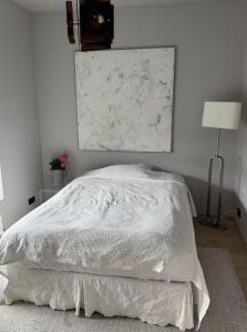 un letto con piumone bianco in una camera da letto di Room in modern downtown apt with private bathroom a Reykjavik