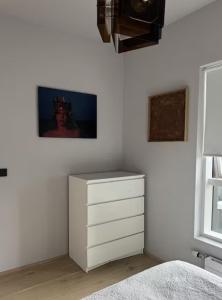 una camera da letto con un comò bianco e un quadro sul muro di Room in modern downtown apt with private bathroom a Reykjavik