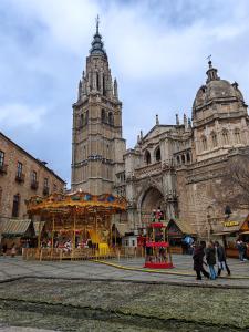 een grote kathedraal met een carrousel ervoor bij VIRGEN de ALFILERITOS in Toledo