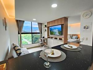 een woonkamer met een tafel met wijnglazen erop bij Cali - Apartaestudios Edificio Miro Living Guadalupe in Cali
