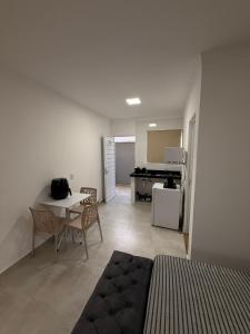 een woonkamer met een tafel en een keuken bij Flats Privativos MaragoJulios in Maragogi