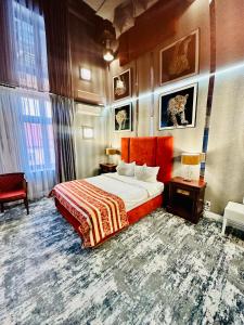 ein Hotelzimmer mit einem Bett, zwei Tischen und einem Fenster in der Unterkunft Villa & Restaurant Levoslav House in Sibiu