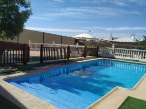 a swimming pool next to a wooden fence at Casa rural en Granada in Atarfe