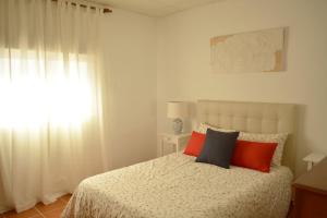 a bedroom with a bed with orange and black pillows at Casa rural en Granada in Atarfe +13 photos