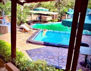 ein Pool mit einer Person im Wasser in der Unterkunft Loft in Kiyovu, Kigali in Kigali