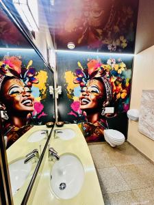 ein Badezimmer mit einem Gemälde von zwei Frauen an der Wand in der Unterkunft Villa & Restaurant Levoslav House in Sibiu + 114 Fotos