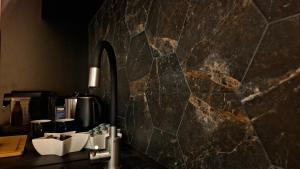 bagno con parete in pietra e specchio di Respiro Villas a Târgu Neamț