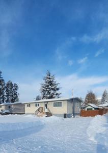 a house with snow in front of it at Mountain Joy Getaway in Valemount +2 photos