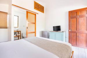 a bedroom with a bed and a tv and a door at La Buena vida Cabina 1 in Playa Grande