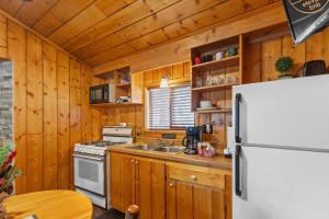 a kitchen with a white refrigerator and a stove at Cabin 4- One Bedroom cabin- RMNP in Estes Park