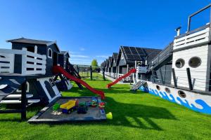 a playground with a slide in the grass at Domeczki Blaneczki Wicie - domki letniskowe nad morzem in Wicie