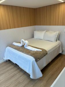 a bed with two towels on top of it at Morada Som do Mar in Governador Celso Ramos