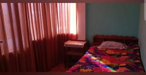 a bedroom with a bed and a sink and a window at Hospedaje Mis Sueños in San Antonio
