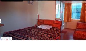 a bedroom with a bed and a dresser and window at Hospedaje Mis Sueños in San Antonio