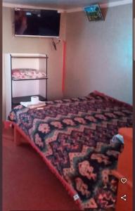a bedroom with a bed and a tv in it at Hospedaje Mis Sueños in San Antonio