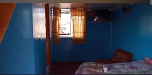a blue room with a bed and a window at Hospedaje Mis Sueños in San Antonio
