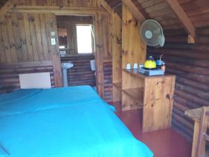 a bedroom with a bed in a log cabin at Tannenhof Countryside Log Cabins in Sanddrif