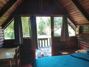 a room with a bed and a window in a cabin at Tannenhof Countryside Log Cabins in Sanddrif