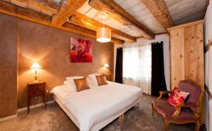 a bedroom with a large white bed and a chair at Gite des Frères Mertian in Ribeauvillé