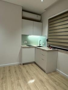 een lege keuken met witte kasten en een wastafel bij Central Tirana Apartments in Tirana +18 foto's