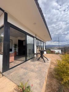 ein Haus mit Glaswänden und einem Picknicktisch auf einer Terrasse in der Unterkunft Glamping Eclipse Mirador Jarana Villa de Leyva 