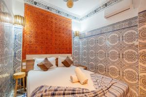 een slaapkamer met een bed en een muur met tegels bij Appart Riad Marrakech in Marrakesh