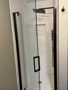una doccia con una porta in vetro in un bagno di Sullivan Trail Cottage a Tannersville