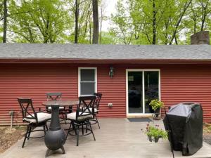 un patio con tavolo e sedie di fronte a una casa rossa di Sullivan Trail Cottage a Tannersville