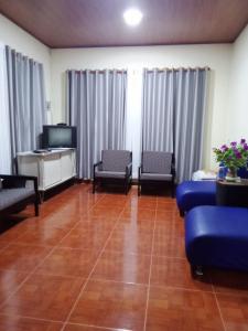 ein Wohnzimmer mit 2 blauen Stühlen und einem TV in der Unterkunft Finca Turistica Rancho Grande in Santana