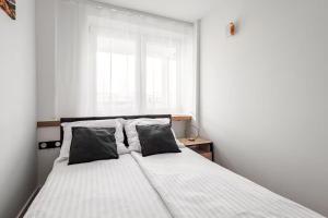 een slaapkamer met een bed met twee kussens en een raam bij Warsaw View Residance in Warschau