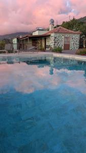 una grande piscina di acqua blu di fronte a un edificio di TIAROSALIA a Tijarafe