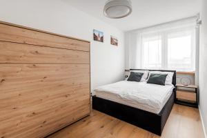 een slaapkamer met een grote houten muur naast een bed bij Warsaw View Residance in Warschau