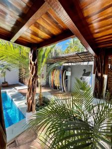 una casa con piscina con una giraffa e delle palme di La Buena vida Cabina 4 a Playa Grande