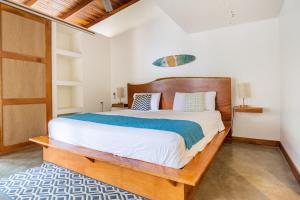 una camera da letto con un letto grande con testiera in legno di La Buena vida Cabina 4 a Playa Grande