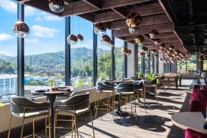 un ristorante con tavoli e sedie e grandi finestre di Hotel Indigo Gatlinburg Downtown by IHG a Gatlinburg