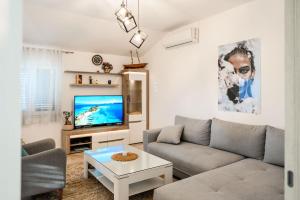 a living room with a couch and a tv at Apartment MATEJA in Tivat