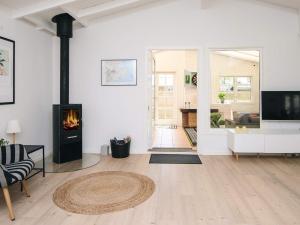 6 person holiday home in Haderslev في هادرسليف: غرفة معيشة مع مدفأة وتلفزيون