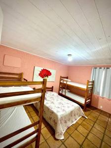 una stanza con due letti a castello e un letto con un fiore di Casa na Praia dos Pesacdores a Itanhaém