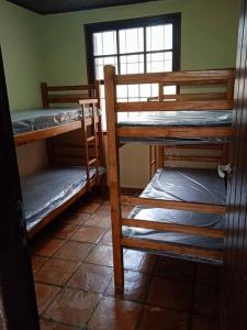 una stanza con tre letti a castello e una finestra di Casa na Praia dos Pesacdores a Itanhaém
