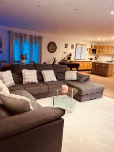 ein Wohnzimmer mit Sofa und Tisch in der Unterkunft Maison spacieuse avec grand jardin Cosne-sur-Loire in Saint-Père