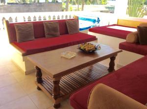 a living room with a couch and a table at Villa Perle Noire in Ambatoloaka